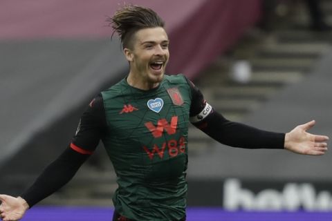 Aston Villa's Jack Grealish celebrates after scoring the opening goal of the game during the English Premier League soccer match between West Ham United and Aston Villa at the London Stadium in London, Sunday, July 26, 2020. (Andy Rain/Pool via AP)