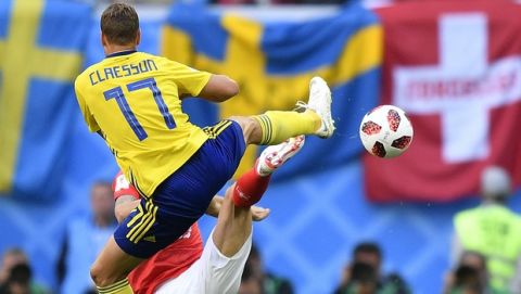 Sweden's Viktor Claesson and Switzerland's Ricardo Rodriguez, rear hidden, challenge for the ball during the round of 16 match between Switzerland and Sweden at the 2018 soccer World Cup in the St. Petersburg Stadium, in St. Petersburg, Russia, Tuesday, July 3, 2018. (AP Photo/Martin Meissner)
