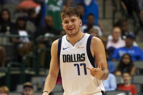 FILE - In this Saturday, Sept. 29, 2018, file photo, Dallas Mavericks guard Luka Doncic (77) celebrates after hitting a 3-pointer against the Beijing Ducks during the second half of an NBA exhibition basketball game in Dallas. Doncic has help from plenty of angles as a teenager transitioning from European ball to the NBA with the Mavericks.  (AP Photo/Cooper Neill, File)
