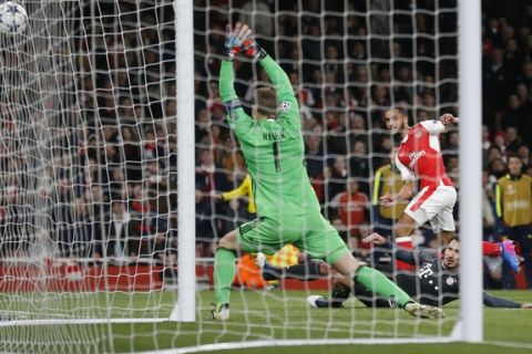 Arsenal's Theo Walcott, right, gets in a shot during the Champions League round of 16 second leg soccer match between Arsenal and Bayern Munich at the Emirates Stadium in London, Tuesday, March 7, 2017. (AP Photo/Frank Augstein)