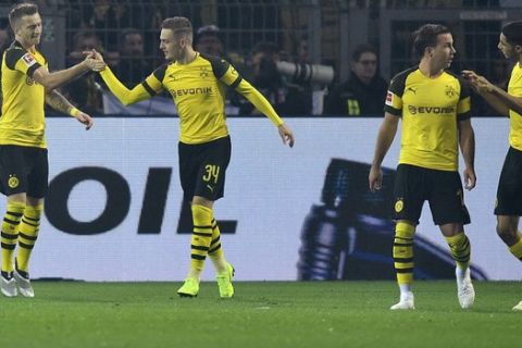 Dortmund's Marco Reus, left, celebrates after scoring his side's opening goal from the penalty point during the German Bundesliga soccer match between Borussia Dortmund and FC Bayern Munich in Dortmund, Germany, Saturday, Nov. 10, 2018. (AP Photo/Martin Meissner)