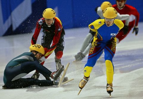 Kim Dong-Sung of Korea nears the finish line as Steven Bradbury of Australia falls, colliding with Andre Hartwig of Germany during the fourth heat of the men's 1,500-meter short-track speedskating race at the Winter Olympics in Salt Lake City, Wednesday, Feb. 20, 2002.  (AP Photo/Roberto Borea)