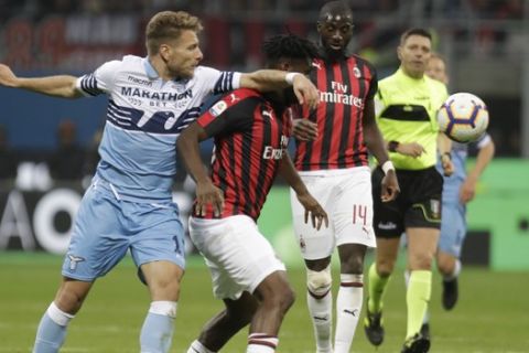 Lazio's Ciro Immobile, left, and AC Milan's Franck Kessie challenge for the ball during the Serie A soccer match between AC Milan and Lazio, at the San Siro stadium in Milan, Italy, Saturday, April 13, 2019. (AP Photo/Luca Bruno)