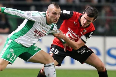 French Saint Etienne forward Yohan Mollo challenges for the ball with French defender Romain Danze of Rennes during their League One soccer match, in Rennes, western France, Friday, March 8, 2013. Match ended on a 2-2 draw. (AP Photo/David Vincent)