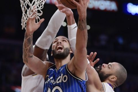 Orlando Magic guard Evan Fournier, center, of France, shoots as Los Angeles Lakers forward LeBron James, left, and center Tyson Chandler defend during the second half of an NBA basketball game Sunday, Nov. 25, 2018, in Los Angeles. The Magic won 108-104. (AP Photo/Mark J. Terrill)