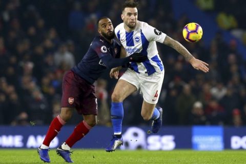 Arsenal's Alexandre Lacazette, left, and Brighton & Hove Albion's Shane Duffy battle for the ball during the English Premier League soccer match at the AMEX Stadium, Brighton, Wednesday Dec. 26, 2018. (Gareth Fuller/PA via AP)