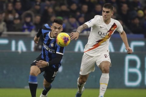 Inter Milan's Lautaro Martinez, left, vies for the ball with Roma's Gianluca Mancini during a Serie A soccer match between Inter Milan and Roma, at the San Siro stadium in Milan, Italy, Friday, Dec.6, 2019. (AP Photo/Luca Bruno)