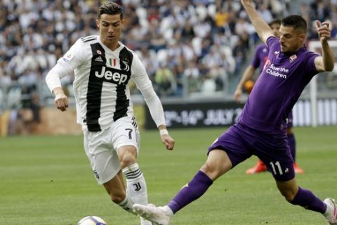 Juventus' Cristiano Ronaldo , left, and Fiorentina's Kevin Mirallas fight for the ball during a Serie A soccer match between Juventus and AC Fiorentina, at the Allianz stadium in Turin, Italy, Saturday, April 20, 2019. Juventus needs a draw against visiting Fiorentina to clinch a record-extending eighth straight Serie A title. (AP Photo/Luca Bruno)