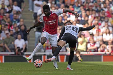 Arsenal's Thomas Partey, left, and Fulham's Sasa Lukic vie for the ball during the English Premier League soccer match between Arsenal and Fulham at Emirates stadium in London, Saturday, Aug. 26, 2023. (AP Photo/Frank Augstein)