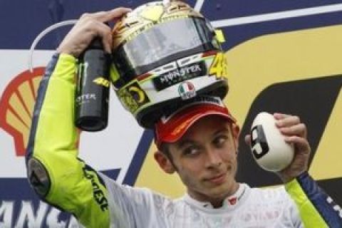 Italy's Valentino Rossi celebrates after winning the World MotoGP Championship with his third place finish at the Malaysian Grand Prix motorcycle racing at the Sepang International Circuit in Sepang, Malaysia, Sunday, Oct. 25, 2009. Australia's Casey Stoner won the race.   (AP Photo/Mark Baker)