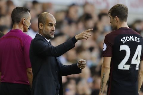 Manchester Citys manager Pep Guardiola, left talks to his player Manchester Citys John Stones during the Premier League soccer match between Tottenham Hotspur and Manchester City at White Hart Lane stadium in London, Sunday, Oct. 2, 2016. (AP Photo/Frank Augstein)
