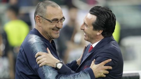 Chelsea head coach Maurizio Sarri, left, shares a moment with Arsenal manager Unai Emery during the Europa League Final soccer match between Arsenal and Chelsea at the Olympic stadium in Baku, Azerbaijan, Wednesday, May 29, 2019. (AP Photo/Luca Bruno)