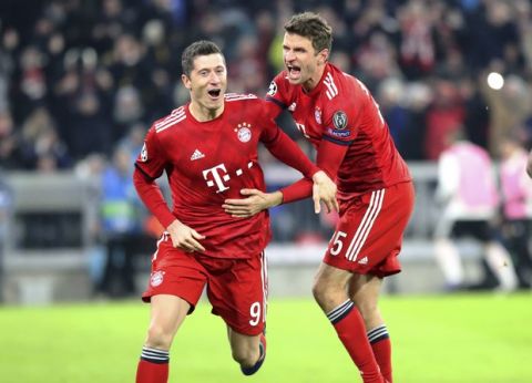 Bayern forward Robert Lewandowski, left, celebrates with Thomas Mueller after scoring his side's fourth goal during the Champions League group E soccer match between FC Bayern Munich and Benfica Lisbon in Munich, Germany, Tuesday, Nov. 27, 2018. (AP Photo/Thomas Schmidtutz)