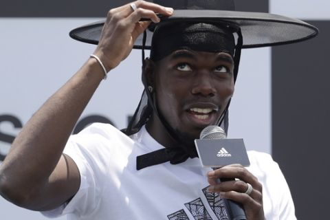 Manchester United's soccer player Paul Pogba, wearing the South Korean traditional hat, speaks during a media day in Seoul, South Korea, Thursday, June 13, 2019. Pogba is in Seoul as a part of his Asian tour. (AP Photo/Lee Jin-man)