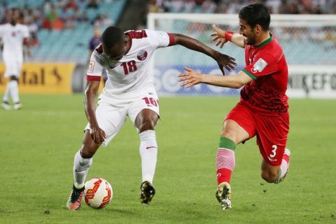 Qatars Mohammed Abdullah Tresor, left, and Iran's Ehsan Hajsafi contest for the ball during the AFC Asia Cup soccer match between Qatar and Iran in Sydney, Australia, Thursday, Jan. 15, 2015. (AP Photo/Rick Rycroft)