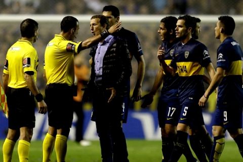 Rodolfo Arruabarrena coach of Argentina's Boca Juniors, center, argues with referee Dario Herrera, second left, at the end of the first half of a Copa Libertadores soccer match against Argentina's River Plate  in Buenos Aires, Argentina,  Thursday, May 14, 2015. (AP Photo/Victor R. Caivano)