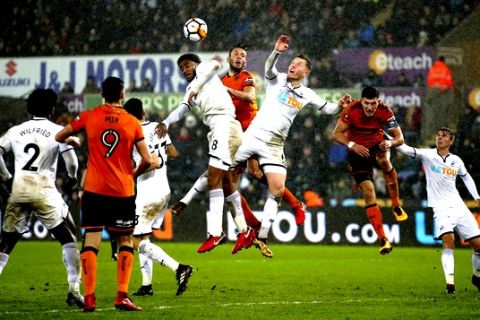 Wolverhampton Wanderers' Roderick Miranda, top centre, battles for an aerial ball with Swansea City players Leroy Fer, centre left, Alfie Mawson, centre right, during their English FA Cup, Third Round Replay soccer match at the Liberty Stadium in Swansea, Wales, Wednesday Jan. 17, 2018. (Nick Potts/PA via AP)