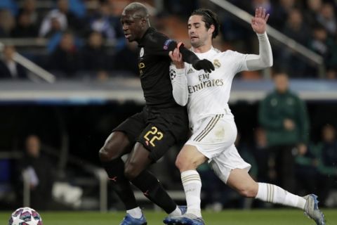 Manchester City's Benjamin Mendy, left, and Real Madrid's Isco challenge for the ball during the round of 16 first leg Champions League soccer match between Real Madrid and Manchester City at the Santiago Bernabeu stadium in Madrid, Spain, Wednesday, Feb. 26, 2020. (AP Photo/Bernat Armangue)
