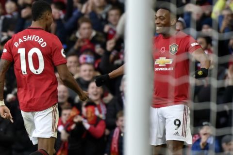 Manchester United's Marcus Rashford, left, celebrates with Manchester United's Anthony Martial after scoring his side's third goal during the English Premier League soccer match between Manchester United and Brighton and Hove Albion, at the Old Trafford stadium in Manchester, England, , Sunday, Nov. 10, 2019. (AP Photo/Rui Vieira)