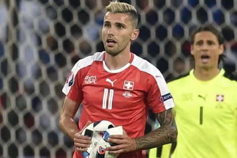 Switzerland's Valon Behrami, holds the ball after it burst during the Euro 2016 Group A soccer match between Switzerland and France at the Pierre Mauroy stadium in Villeneuve dAscq, near Lille, France, Sunday, June 19, 2016. (AP Photo/Martin Meissner)