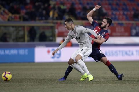 Juventus' Cristiano Ronaldo, left, challenges for the ball with Bologna's Arturo Calabresi during a round of 16 Italian Cup soccer match between Bologna and Juventus at the Renato Dall'Ara stadium in Bologna, Italy, Saturday, Jan. 12, 2019. (AP Photo/Luca Bruno)