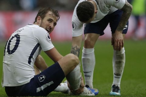 Tottenham Hotspur's Harry Kane, left looks round after falling to the ground during the English Premier League soccer match between Tottenham Hotspur and Arsenal at Wembley stadium in London, Saturday, Feb. 10, 2018. (AP Photo/Matt Dunham)