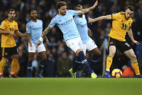 Manchester City's Kyle Walker, left, challenges for the ball with Wolverhampton Wanderers' Diogo Jota, right, during the English Premier League soccer match between Manchester City and Wolverhampton Wanderers at the Etihad Stadium in Manchester, England, Monday, Jan. 14, 2019. (AP Photo/Dave Thompson)