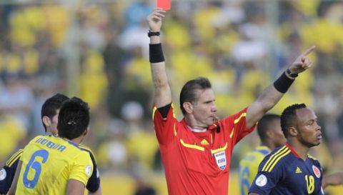 Referee Wilson Seneme, center, of Brazil, issues a red cart to Ecuador's Christian Noboa (6) during a World Cup qualifying soccer game in Quito, Ecuador, Sunday, June 10, 2012. (AP Photo/Dolores Ochoa)