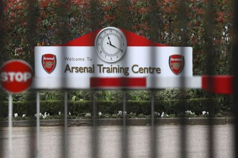 Closed gates at Arsenal's London Colney training ground in London, Friday, March 13, 2020. Arsenal manager Mikel Arteta has tested positive for the coronavirus. It has forced the club to close its training complex, put the entire first-team in self isolation and for its Premier League match against Brighton on Saturday to be postponed. (Bradley Collyer/PA via AP)