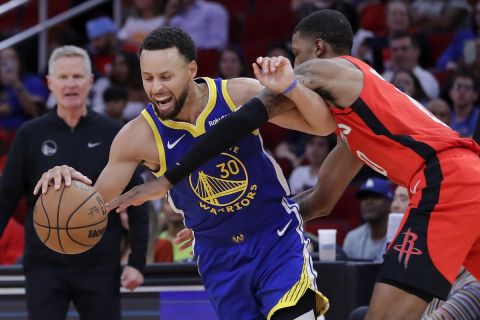 Golden State Warriors guard Stephen Curry (30) tries to drive past Houston Rockets forward Jabari Smith Jr., right, who reaches for the ball during the second half of an NBA basketball game Sunday, Oct. 29, 2023, in Houston. (AP Photo/Michael Wyke)