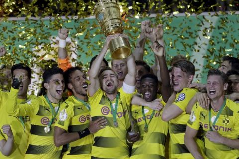 Dortmund's Marcel Schmelzer,raises the cup after Dortmund won the German soccer cup final match between Borussia Dortmund and Eintracht Frankfurt in Berlin, Germany, Saturday, May 27, 2017. (AP Photo/Michael Sohn)
