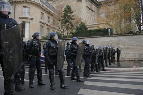Riot police officers guard the National Assembly in Paris, Monday, Dec. 3, 2018. Ambulance workers took to the streets and gathered close to the National Assembly in downtown Paris to complain about changes to working conditions as French Prime Minister Edouard Philippe is holding crisis talks with representatives of major political parties in the wake of violent anti-government protests that have rocked Paris. (AP Photo/Michel Euler)