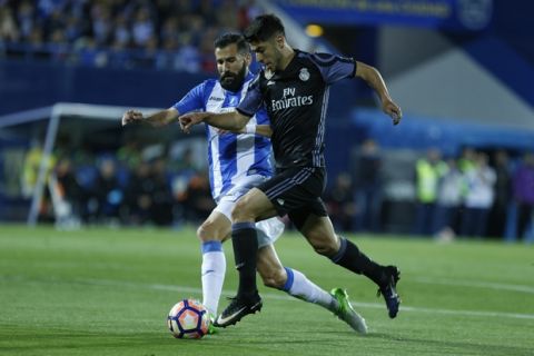 Real Madrid's Marco Asensio vies for the ball with Leganes' Dimitrios Siovas, left, during a Spanish La Liga soccer match between Leganes and Real Madrid at the Butarque stadium in Madrid, Wednesday, April 5, 2017. (AP Photo/Francisco Seco)