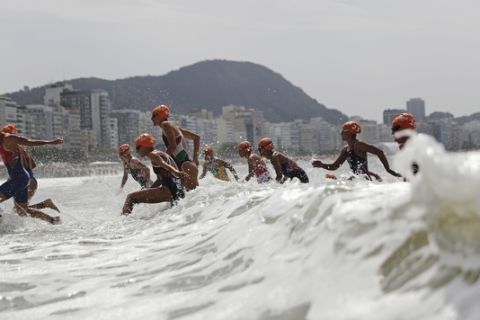 Competitors exit the water as they transition from the swim to bike portion of the women's triathlon event at the 2016 Summer Olympics in Rio de Janeiro, Brazil, Saturday, Aug. 20, 2016. (AP Photo/David Goldman)