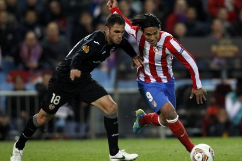 Atletico Madrid's Radamel Falcao (R) eludes Valancia's Victor Ruiz just before scoring his second goal during their Europa League semi-final first leg soccer match at Vicente Calderon stadium in Madrid April 19, 2012. REUTERS/Susana Vera (SPAIN  - Tags: SPORT SOCCER)  