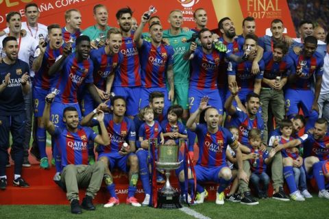 Barcelona team players pose with the trophy after the Copa del Rey final soccer match between Barcelona and Alaves at the Vicente Calderon stadium in Madrid, Spain, Saturday, May 27, 2017. Barcelona won the match 3-1. (AP Photo/Francisco Seco)
