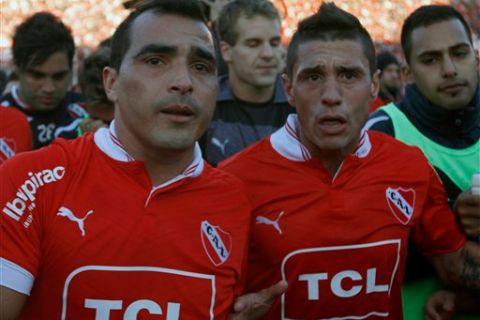 Independiente's Claudio Morel Rodriguez, left, and Independiente's Cristian Tula, right, leave the field at the end of an Argentine soccer match between Independiente and San Lorenzo in Buenos Aires, Argentina, Saturday, June 15, 2013. After loosing 1-0, Independiente was relegated to the Argentine second division soccer league for the first time in its 108-year history. (AP Photo/Daniel Jayo)