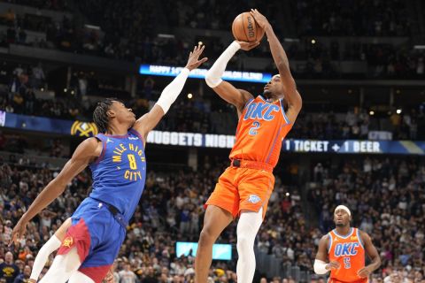 Oklahoma City Thunder guard Shai Gilgeous-Alexander (2) goes up to shoot the winning basket over Denver Nuggets forward Peyton Watson (8) with less than a second remaining in the second half of an NBA basketball game Saturday, Dec. 16, 2023, in Denver. (AP Photo/David Zalubowski)