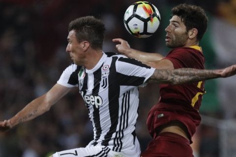 Juventus' Mario Mandzukic, left, and Roma's Federico Fazio vie for the ball during a Serie A soccer match between Roma and Juventus, at the Rome Olympic stadium, Sunday, May 13, 2018. (AP Photo/Gregorio Borgia)