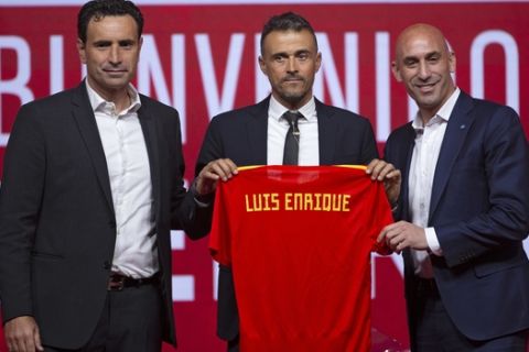 Spanish coach Luis Enrique, centre, Spanish football President Luis Rubiales, right, and Spanish football sports director Jose Francisco Molina pose for the media during the official presentation of Luis Enrique as Spain new head coach in Las Rozas, on the outskirts of Madrid, Thursday, July 19, 2018. (AP Photo/Francisco Seco)