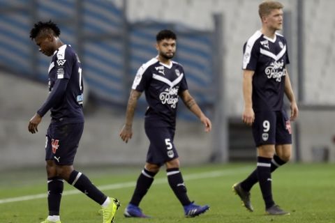 Bordeaux's Samuel Ojim, left, walks out the pitch after receiving a red card as teammates Otavio Pasos Santos, center, and Andreas Cornelius, right, look on during the French League One soccer match between Marseille and Bordeaux at the Velodrome Stadium in Marseille, Tuesday, Feb. 5, 2019. (AP Photo/Claude Paris)
