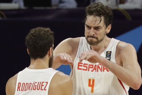 Russia's Timofey Mozgov, right, walks past as Spain's Pau Gasol, center, celebrates points with Spain's Sergio Rodriguez, left, during their Eurobasket European Basketball Championship bronze medal match in Istanbul, Sunday, Sept. 17. 2017. (AP Photo/Thanassis Stavrakis)