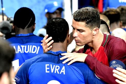 Portugal's Cristiano Ronaldo, right, embraces France's Patrice Evra at the end of  the Euro 2016 final soccer match between Portugal and France at the Stade de France in Saint-Denis, north of Paris, Sunday, July 10, 2016. Portugal won 1-0. (AP Photo/Martin Meissner)