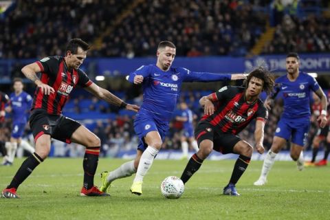 Chelsea's Eden Hazard, centre, takes the ball past Bournemouth's Charlie Daniels, left and Nathan Ake during a League Cup, quarterfinal soccer match between Chelsea and Bournemouth at the Stamford Bridge stadium in London, Wednesday Dec. 19, 2018. (AP Photo/Alastair Grant)