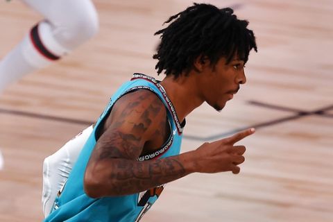 Memphis Grizzlies' Ja Morant reacts to his three-point basket against the Toronto Raptors during the first quarter of an NBA basketball game Sunday, Aug. 9, 2020, in Lake Buena Vista, Fla. (Kevin C. Cox/Pool Photo via AP)