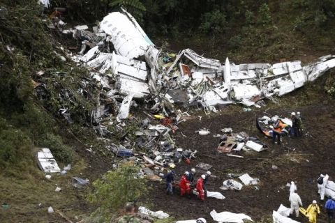 FILE - In this Nov. 29, 2016 file photo, rescue workers recover a body from the wreckage site of an airplane crash, in La Union, a mountainous area near Medellin, Colombia. A LaMia jet carrying 77 people slammed into the Colombian mountainside just minutes after the pilot reported running out of fuel. The crash killed 71 of 77 aboard, including members of Brazil's Chapecoense soccer team and a group of journalists who were traveling to the Copa Sudamericana finals. (AP Photo/Fernando Vergara, File)