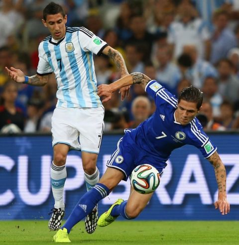 RIO DE JANEIRO, BRAZIL - JUNE 15: Angel di Maria of Argentina challenges Muhamed Besic of Bosnia and Herzegovina during the 2014 FIFA World Cup Brazil Group F match between Argentina and Bosnia-Herzegovina at Maracana on June 15, 2014 in Rio de Janeiro, Brazil.  (Photo by Jamie Squire/Getty Images)
