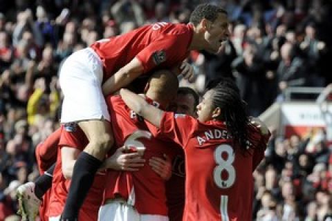 Manchester United's English defender Rio Ferdinand (top) jumps on to Manchester United's English defender Wes Brown (2L) after his goal during the English Premier league football match against Liverpool at Old Trafford, in Manchester, north-west England, on March 23, 2008. AFP PHOTO/ANDREW YATES  Mobile and website use of domestic English football pictures are subject to obtaining a Photographic End User Licence from Football DataCo Ltd Tel : +44 (0) 207 864 9121 or e-mail accreditations@football-dataco.com - applies to Premier and Football League matches. (Photo credit should read ANDREW YATES/AFP/Getty Images)