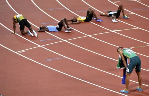 South Africa's Wayde Van Niekerk, right, rests after winning the Men's 400 meters final at the World Athletics Championships in London Tuesday, Aug. 8, 2017. (AP Photo/Martin Meissner)