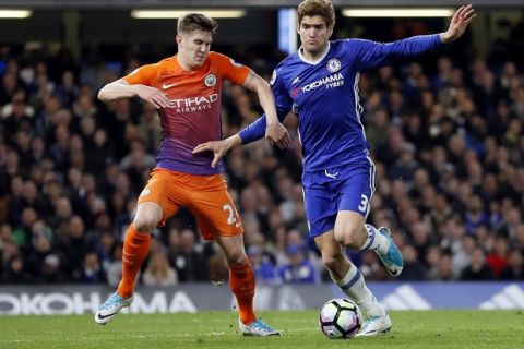 Manchester City's John Stones, left, and Chelsea's Marcos Alonso, right, challenge for the ball during the English Premier League soccer match between Chelsea and Manchester City at the Stamford Bridge stadium in London, Great Britain, Wednesday, April 5, 2017. (AP Photo/Kirsty Wigglesworth)